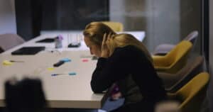 Berufsunfähigkeit bei rezidivierender Depression: Rechtliche Einordnung und Handlungsmöglichkeiten Frau im Büro leidet unter Erschöpfung und Depression – Berufsunfähigkeit durch rezidivierende Depression